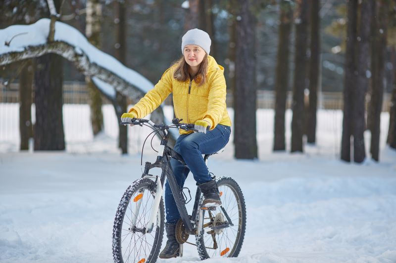 Frau auf Fahrrad im Schnee